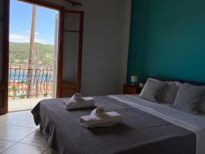 een slaapkamer met een bed met handdoeken erop bij Albatros rooms in Vathi