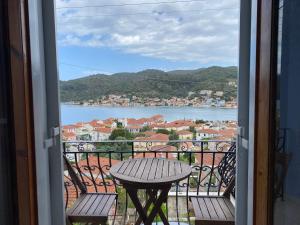 een balkon met een tafel en uitzicht op het water bij Albatros rooms in Vathi