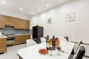 een keuken met een tafel met wijnglazen en fruit erop bij Premium 2 Bedroom Apartment lll in Tbilisi City