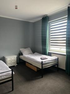 1 dormitorio con 2 camas y ventana en Gościniec en Myszęcin