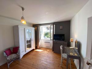 a living room with a dining room table and a window at Maison 6 pers, jardin, terrasse, parking, plage proche - FR-1-542-27 in Kerjagu
