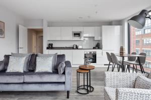 uma sala de estar com um sofá e uma mesa em Modern & Spacious Apartment In Central Birmingham em Birmingham