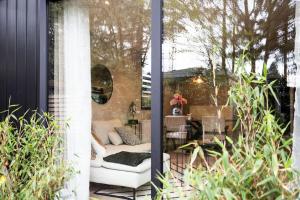 a patio with a white couch and a table at Veluwe Boutique Lodge in Putten