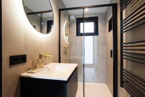 a bathroom with a sink and a shower and a mirror at Veluwe Boutique Lodge in Putten