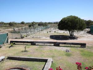 a garden with a fence and a tree at Tula Guest Farm in Yzerfontein