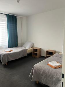 a hotel room with two beds and a window at Gościniec in Myszęcin