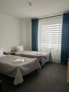 Zimmer mit 2 Betten und einem Fenster in der Unterkunft Gościniec in Myszęcin