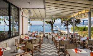 バルドリーノにあるHotel Nettunoのテーブルと椅子が備わるレストランで、水辺の景色を望めます。