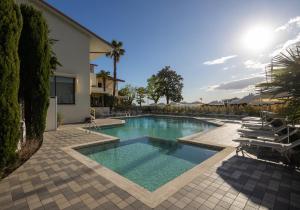 a swimming pool in a yard with lounge chairs at Hotel Nettuno in Bardolino