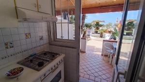 a kitchen with a stove and a view of a patio at Casa del Mare in Forio d'Ischia