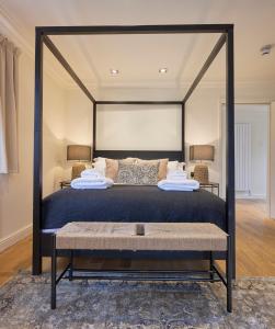 a bedroom with a large canopy bed with a bench at Wilding Hotel in Brough