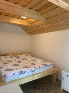 uma cama num quarto com tecto em madeira em chata-brdy em Nové Mitrovice
