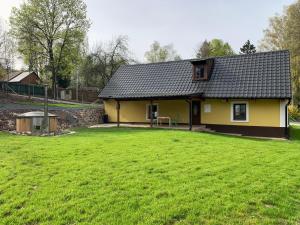 a yellow house with a large yard in front of it at chata-brdy in Nové Mitrovice