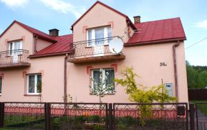 a pink house with a red roof at Domek Pod Różą in Krasnobród