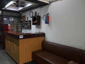 ein Restaurant mit einer Theke und eine Bar mit einem Sofa in der Unterkunft Hotel Atithi Galaxy Kanpur Near Railway Station Kanpur - Wonderfull Stay with Family in Kānpur