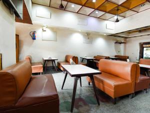 a waiting room with brown leather chairs and tables at Hotel Atithi Galaxy Kanpur Near Railway Station Kanpur - Wonderfull Stay with Family in Kānpur