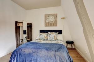 Schlafzimmer mit einem Bett mit blauer Decke in der Unterkunft Le Havre de Paix - Abondant in Abondant