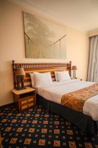 Un pat sau paturi într-o cameră la Om Kalthom Hotel