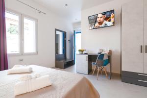 - une chambre avec un lit et un bureau avec une télévision murale dans l'établissement Blue Sea, à Posada