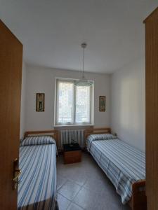 a bedroom with two beds and a window at Fiore in Pieve Di Ledro