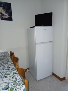 a white refrigerator with a television on top of it at Fiore in Pieve Di Ledro
