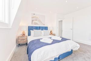 1 dormitorio con 1 cama grande y cabecero azul en The Residence by Guestz, en Cheltenham