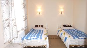 two twin beds in a room with a window at Domek Pod Różą in Krasnobród