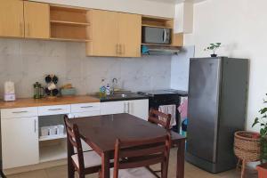 a kitchen with a table and a stainless steel refrigerator at Free Parking- Good for 4pax Makati Condo near CBD in Manila