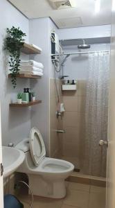 a bathroom with a shower and a toilet and a sink at Free Parking- Good for 4pax Makati Condo near CBD in Manila