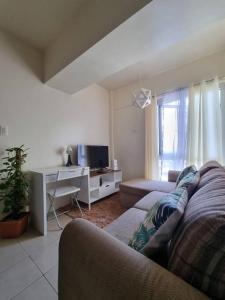 a living room with a couch and a tv at Free Parking- Good for 4pax Makati Condo near CBD in Manila