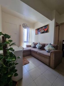 a living room with a couch and a plant at Free Parking- Good for 4pax Makati Condo near CBD in Manila