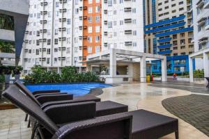 a courtyard with chairs and a pool in a building at Free Parking- Good for 4pax Makati Condo near CBD in Manila