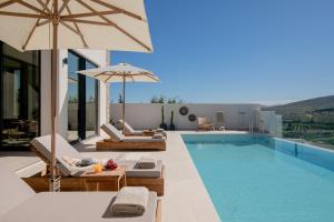 una piscina con tumbonas y sombrilla en Anantia Villa 2 - Scenic View, Luxury Experience, en episkopi-heraklion