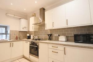 a kitchen with white cabinets and a microwave at Al's Kingsdown Parade F1 in Bristol