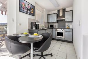 a kitchen with a table and chairs in a kitchen at Ferienwohnung Rheinblick in Küssaberg