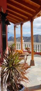 Casas Rurales El Serrillal في إرميغوا: شرفة مع طاولة وإطلالة على الجبال