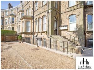 a large building with a fence in front of it at Bright & Spacious Central Apartment in Harrogate