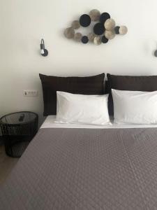 a bed with white pillows and clocks on the wall at Ocean Sun 3 in Éxo Goniá