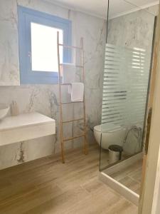 a bathroom with a shower and a toilet and a sink at Ocean Sun 3 in Éxo Goniá