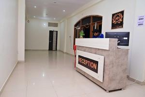 a person sitting at a reception desk in a lobby at Hotel Nath Palace Chunar Road Varanasi - Luxury Room - Excellent Service Recommended in Varanasi