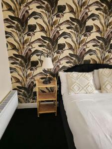 a bedroom with a bed and a table with a lamp at Homely one bed apartment on main road with easy access to city or Peak District in Heeley