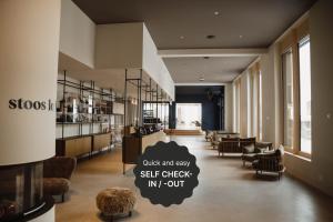 una hall con area salotto con sedie e tavoli di Stoos Lodge a Stoos Altre 37 foto