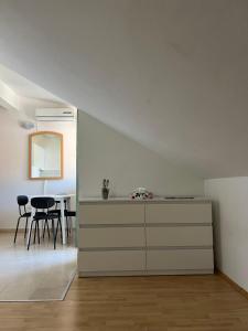 a white room with a dresser and a table at Apartman Kalac in Korčula
