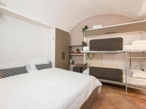 um quarto com uma cama branca e prateleiras em I Host Apartment - Volta Lierna em Lierna