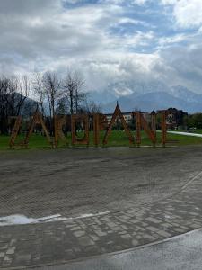 Una valla de madera en un estacionamiento con montañas al fondo. en Apartament Śnieżka, en Zakopane