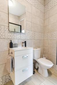 a bathroom with a toilet and a sink and a mirror at Stylish 2 Bedroom Ensuite Flat in Birmingham in Birmingham