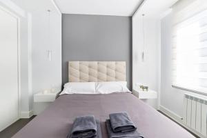 a bedroom with a large bed with two towels on it at Tranquilo Apartamento en pleno corazón de Pamplona in Pamplona