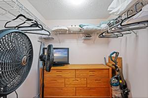 a room with a desk with a computer on a dresser at Ground floor beachfront with steps to the beach and pool & beach access in New Smyrna Beach