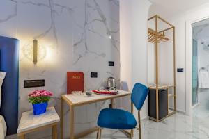 Zimmer mit einem Tisch und zwei blauen Stühlen in der Unterkunft Miss Suite in Rom
