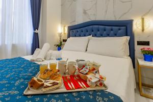 ein Tablett mit Essen auf dem Bett in der Unterkunft Miss Suite in Rom